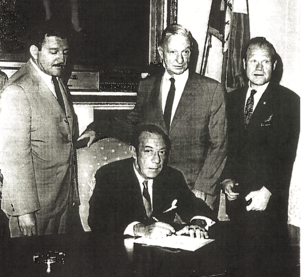Photo of the swearing-in of the first Landmarks Preservation Commission, June 29, 1965. From left to right, Stanley Tankel, Vice-Chair, Mayor Robert Wagner, Geoffrey Platt, Chair, and Sam Lefrak, Commissioner. At times, this photo has been misidentified as the signing of the Landmarks Law. | Courtesy of Anthony C. Wood Archives